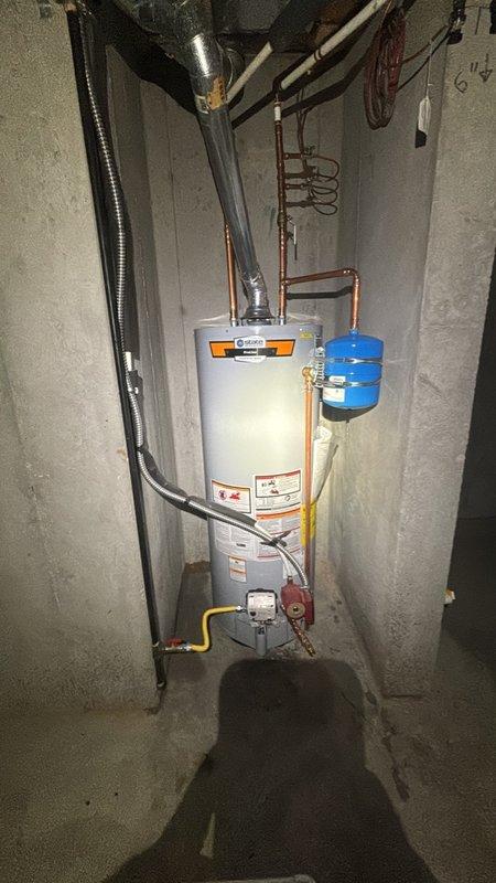 Completed installation of a 50-gallon residential gas water heater in basement utility area, including all required plumbing connections with copper piping and proper fittings. Installed thermal expansion tank with appropriate mounting and copper line connections to protect the system from pressure buildup. Connected gas supply line with shut-off valve and established proper venting through metallic flue pipe to existing ductwork. Additionally performed swap-out of existing Matrix MX water softener system, ensuring proper integration with the new water heater installation. Installed recirculation pump with copper piping connections to facilitate hot water circulation throughout the residence. All connections were tested and verified for proper operation, with no leaks detected at any junction points.