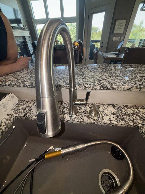 Responded to kitchen faucet repair request where handle was reported broken and required replacement. Successfully installed new brushed stainless steel pull-down faucet with contemporary curved spout design, replacing the damaged unit. Verified proper operation of pull-down spray head, water flow, and handle functionality upon completion.
