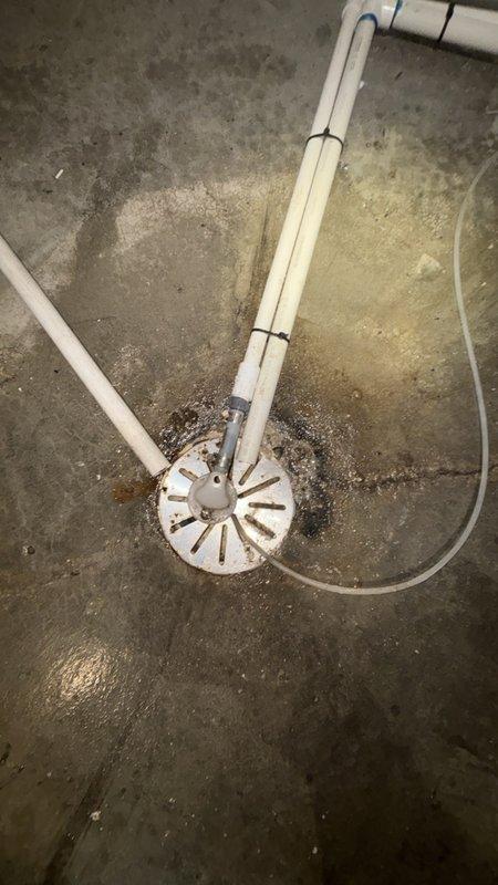 Responded to a clogged floor drain in the basement. Upon inspection, found the main drain cleanout assembly showing signs of backup with visible water staining and moisture on the surrounding concrete floor. Successfully cleared the obstruction from the floor drain system, restoring proper drainage flow through the PVC drain lines connected to the cleanout assembly.