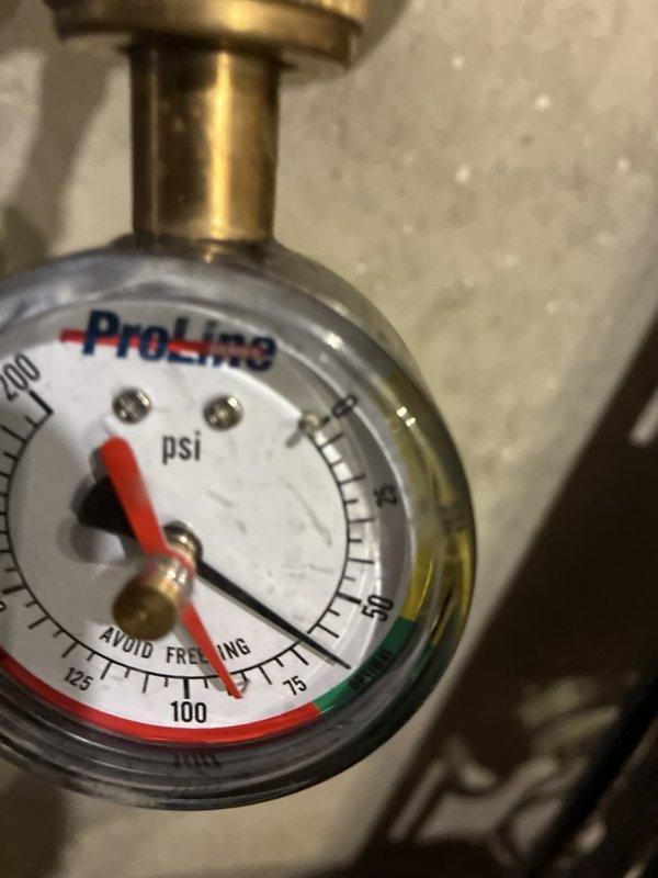 Completed comprehensive plumbing maintenance inspection including tankless water heater flush and system pressure verification. Documented water system pressure gauge readings showing normal operating parameters and confirmed proper function of residential water heater and associated plumbing components in basement utility area.
