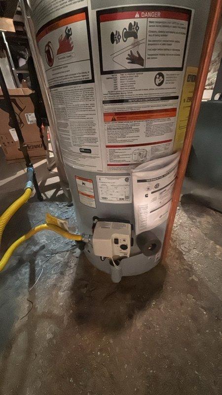Installed a new 40-gallon power vent water heater with thermal expansion tank in the basement utility area. The unit was properly positioned on the concrete floor with all required safety labels and specifications clearly visible. Connected the gas supply line using yellow corrugated flexible tubing to the white control valve assembly at the base of the heater. Completed all necessary plumbing connections and installed the thermal expansion tank to protect against pressure buildup in the closed water system. Verified proper venting configuration for the power vent system through the attic space, with flexible ductwork routed appropriately through structural supports and insulation. All connections were tested and confirmed operational per manufacturer specifications and local code requirements.