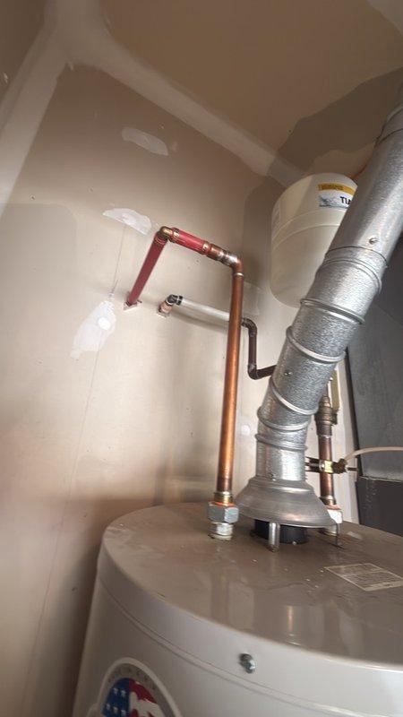 Responded to urgent call for water leak near furnace and hot water heater in utility closet. Upon inspection, examined all copper piping, connections, and fittings throughout the mechanical space, including water heater supply lines with yellow insulation sleeves and pressure relief valve assembly. Thoroughly inspected flexible ductwork connections, PVC drainage and venting systems, and all visible plumbing joints for signs of active leakage or moisture. Checked water heater tank exterior, control panel area, and base connections where copper pipes with brass fittings connect to unit. No active leak was identified during the inspection period; all connections, joints, and fixtures appeared dry with no visible water damage, staining, or moisture accumulation on flooring or surrounding surfaces. Documented existing plumbing configuration with photographs for reference. Advised that intermittent leaks can be difficult to diagnose without active water flow and recommended monitoring the ar