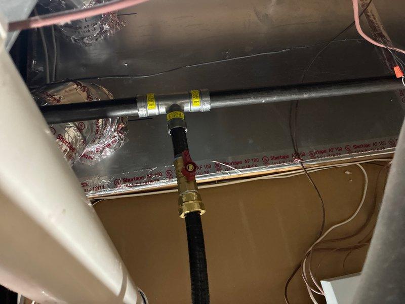 Completed installation of Rinnai RX199 tankless water heater system in attic space. Installation included routing copper supply lines, gas line connections with flexible yellow CSST tubing, condensate drainage via PVC piping, and exhaust venting with appropriate termination. All connections tested and system commissioned for proper operation.