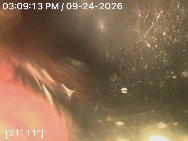 Cleared main drain line of root intrusion through toilet flange access point in bathroom. Utilized drain auger to remove root blockage at approximately 21 feet 11 inches from entry point, restoring proper drainage flow through the main sewer line.