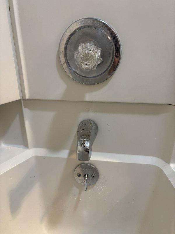 Responded to service call for dripping shower in first floor hall bathroom. Upon inspection, identified worn diverter valve assembly causing continuous water drip from tub spout. Disassembled existing chrome diverter control valve, noting significant mineral deposit buildup and deteriorated internal components contributing to seal failure. Replaced faulty diverter valve cartridge and reassembled fixture assembly. Tested operation to verify proper water flow diversion between tub spout and shower head with no residual dripping. System restored to full functionality.