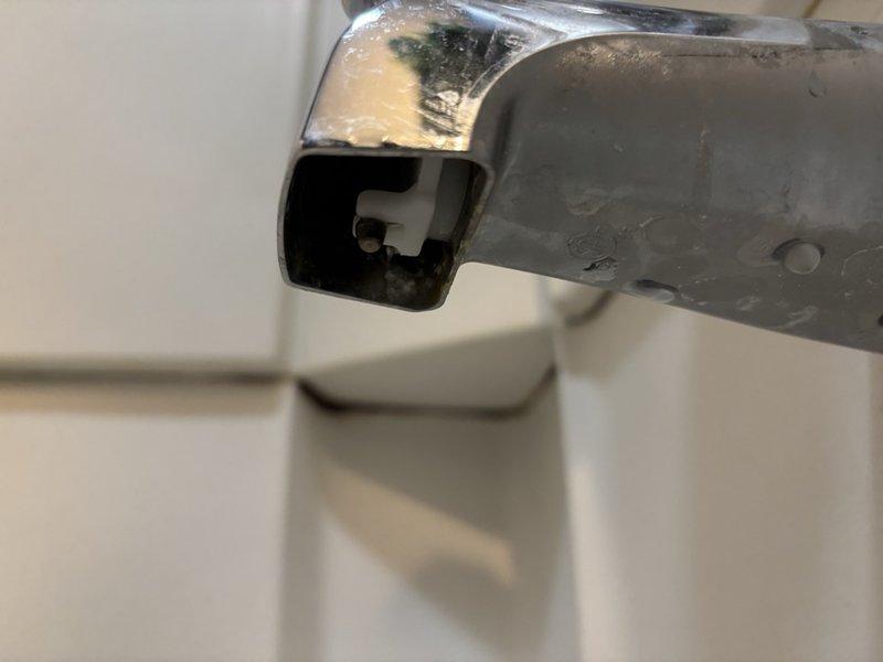 Responded to service call for dripping shower in first floor hall bathroom. Upon inspection, identified worn diverter valve assembly causing continuous water drip from tub spout. Disassembled existing chrome diverter control valve, noting significant mineral deposit buildup and deteriorated internal components contributing to seal failure. Replaced faulty diverter valve cartridge and reassembled fixture assembly. Tested operation to verify proper water flow diversion between tub spout and shower head with no residual dripping. System restored to full functionality.