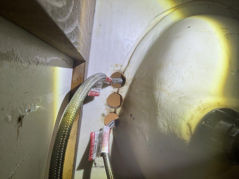 Responded to leak locate service call for main bathroom sink with broken knob causing water intrusion into basement below. Upon inspection, found faucet assembly compromised with damaged handle mechanism leading to active leak at supply connections. Disassembled faucet components to assess extent of damage and trace leak path through floor assembly. Located source of water penetration at deteriorated supply line connections beneath vanity cabinet. Inspected basement ceiling area directly below fixture and identified water damage along copper supply piping and flexible supply hoses. Documented condition of faucet hardware, supply connections, and affected piping infrastructure. Provided assessment of necessary repairs including faucet replacement and potential supply line service to resolve leak and prevent further water damage.