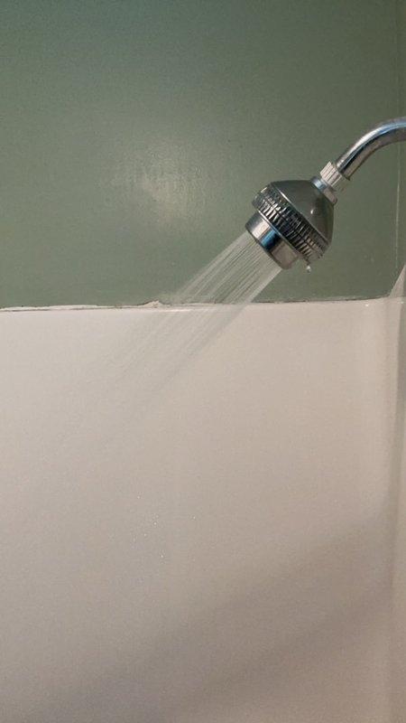 Responded to low water pressure complaint at shower following previous day's leak repair. Upon inspection, discovered flow restrictor had become partially dislodged during handle replacement work, significantly reducing water flow. Removed handheld shower head, extracted and properly reinstalled flow restrictor to manufacturer specifications. Tested water pressure and confirmed restoration to normal operating levels. Verified no leaks present at handle or shower head connections.