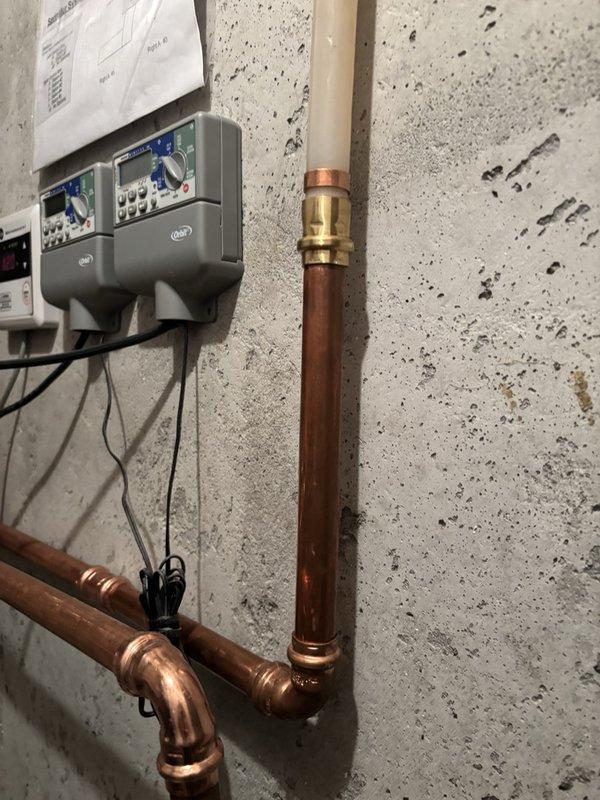 Completed installation of a 2-stage whole home water filtration system with full bypass configuration. Installed dual filter housings with mounting manifold, integrated copper piping with appropriate fittings and valves, and connected electronic control unit for system operation. All components properly secured to wall, bypass valves installed for maintenance accessibility, and system tested for proper flow and function.