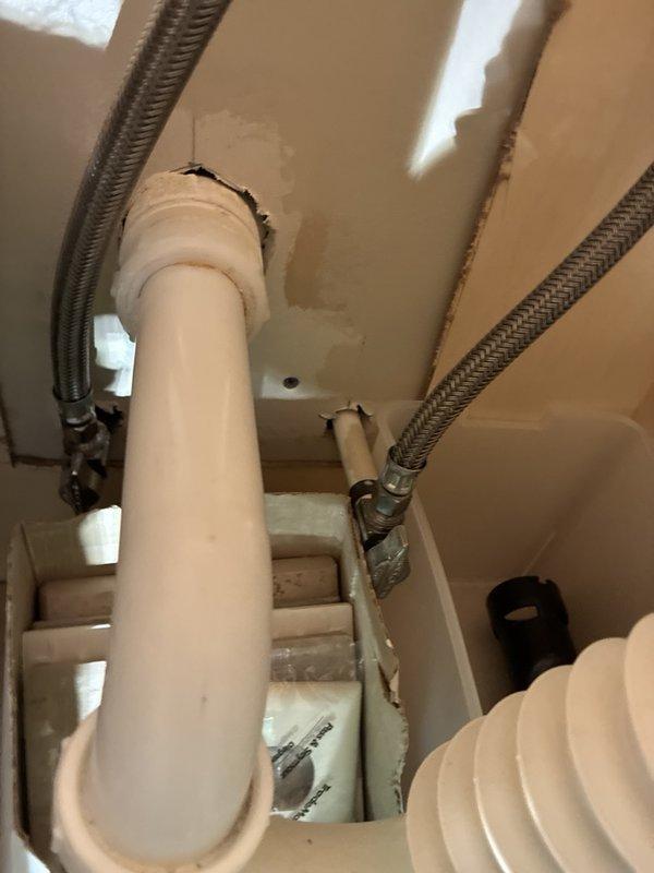 Performed plumbing maintenance inspection on building mechanical systems. Examined HVAC unit connections and verified integrity of braided metal supply lines and flexible conduits with proper fittings and seals. Inspected exposed plumbing assembly in wall cavity, including galvanized pipe fittings, copper supply lines showing oxidation, red-handled shut-off valve, and pressure gauge reading at zero. Documented current condition of all components with photographs for maintenance records.