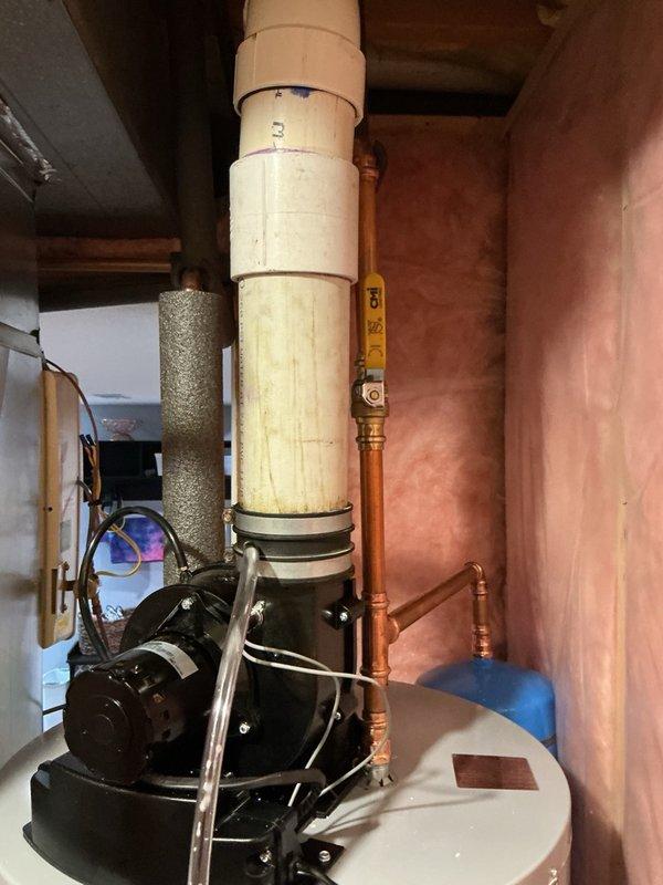 Completed installation of a 50-gallon power vent water heater with thermal expansion tank in basement utility area. Connected all necessary plumbing lines including copper water supply piping, installed yellow-handled gas shutoff valve, and routed flexible gas connector to unit. Mounted thermal expansion tank to system to protect against pressure buildup from thermal expansion in closed plumbing systems. Installed power vent exhaust system with PVC venting to safely remove combustion gases. Verified all connections for proper operation, tested gas line for leaks, confirmed adequate combustion air supply, and ensured unit met all local code requirements for clearances and safety devices.