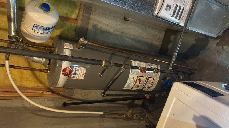Responded to reported water heater leak in basement. Upon arrival, inspected Rheem/Ruud gas-fired water heater and associated plumbing connections. Identified source of leak and performed necessary repairs to resolve the issue. Verified all copper piping, brass fittings, valves, and expansion tank connections for proper operation. Tested system for leaks following repair completion and confirmed water heater returned to normal functioning condition.