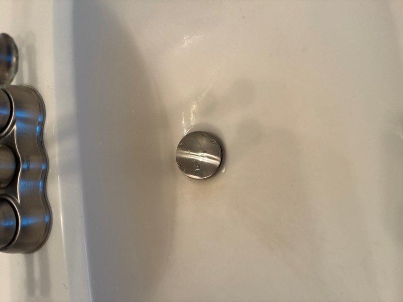 Returned to property to complete installation of new pop-up drain assembly in bathroom sink, ensuring proper fit and seal of chrome stopper mechanism. Investigated and resolved whistling noise issue in master bathroom toilet by inspecting fill valve and supply line connections. Verified all plumbing connections were secure and tested both fixtures for proper operation and leak-free performance.