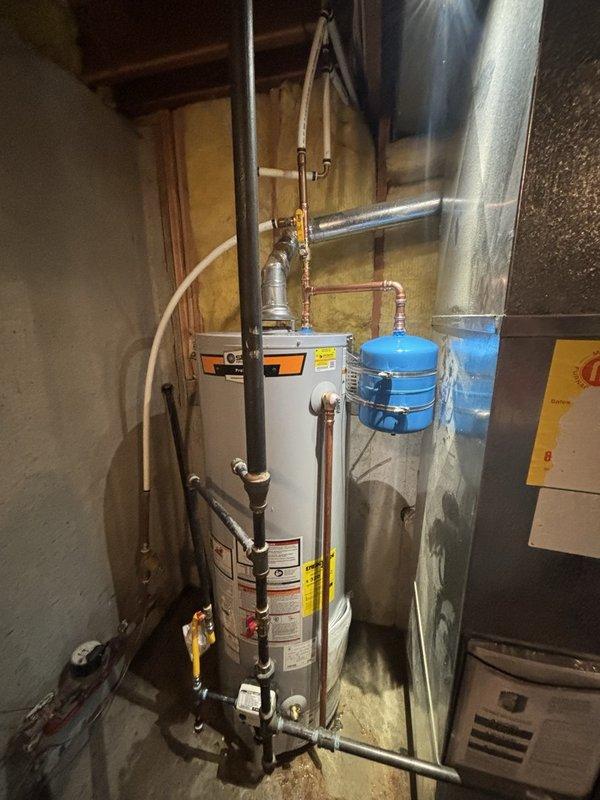 Completed installation of a 40-gallon gas-fired water heater in residential utility room. Configured copper piping connections at unit inlet and outlet, installed thermal expansion tank on cold water supply line to protect against pressure buildup from thermal expansion. Verified all connections for proper sealing, confirmed gas line connections meet code requirements, and ensured adequate clearances around unit for service access and combustion air circulation.