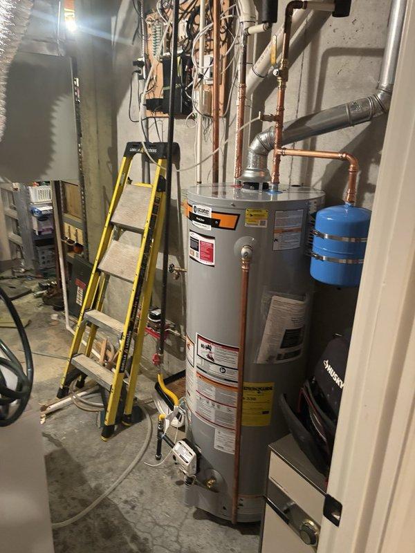 Installed a 50-gallon gas water heater in the basement utility area with proper copper piping connections and metallic exhaust venting. Coordinated with HVAC technician to install a 1/4 turn ball valve for the existing humidifier system, replacing the previous saddle valve configuration. All plumbing connections were secured, expansion tank was properly positioned, and the installation was completed to code specifications.