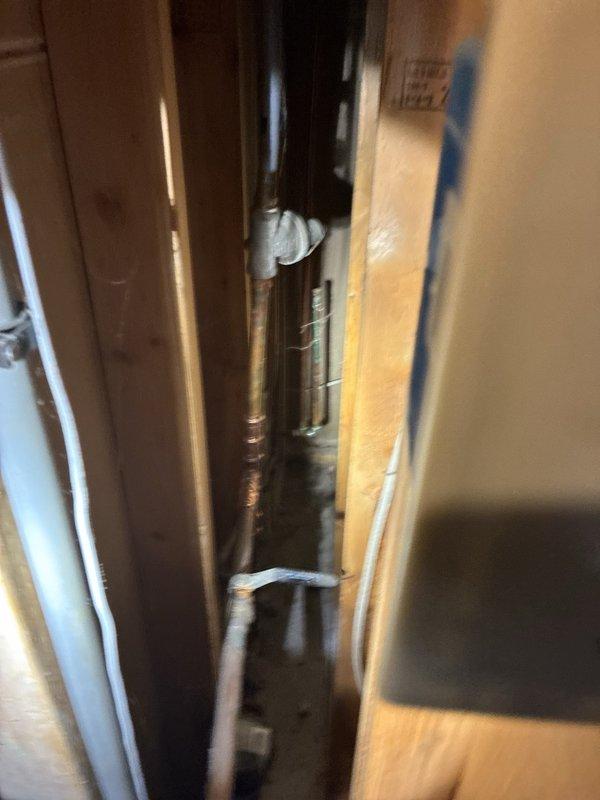 Completed comprehensive plumbing inspection of single-unit residential property. Examined refrigerant lines and plumbing pipes running through interior wall cavity, noting copper piping with visible corrosion and insulated black tubing with foam wrapping at connection points. Tested bathroom fixtures including brushed stainless steel faucet assembly with dual-handle configuration, verifying proper water flow, pressure, and drainage at undermount sink. All accessible plumbing components inspected and documented photographically per standard protocol.