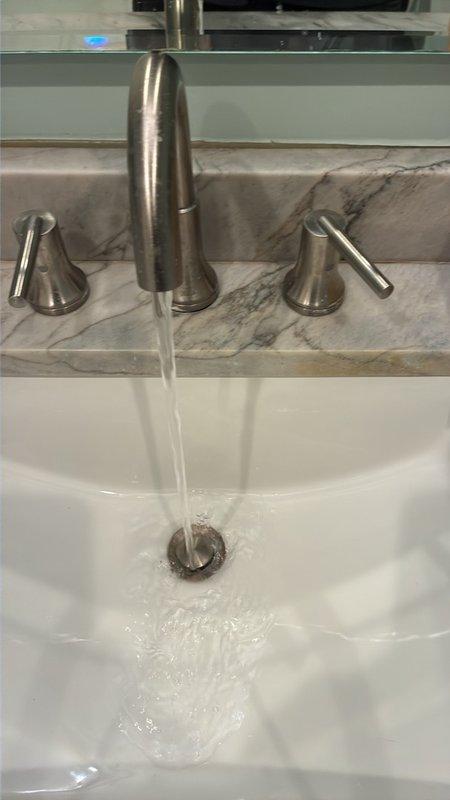 Completed comprehensive plumbing inspection of single-unit residential property. Examined refrigerant lines and plumbing pipes running through interior wall cavity, noting copper piping with visible corrosion and insulated black tubing with foam wrapping at connection points. Tested bathroom fixtures including brushed stainless steel faucet assembly with dual-handle configuration, verifying proper water flow, pressure, and drainage at undermount sink. All accessible plumbing components inspected and documented photographically per standard protocol.