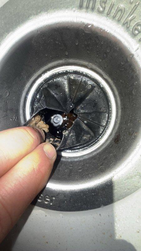 Responded to service call for locked-up garbage disposal in kitchen. Upon inspection, identified jamming issue preventing disposal operation. Accessed disposal unit from beneath sink cabinet, freed impeller mechanism, and restored full functionality. Tested unit to verify proper operation and confirmed splash guard assembly was properly seated and functioning correctly.