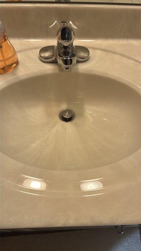 Completed comprehensive whole home plumbing inspection of residential property. Examined bathroom fixtures including cultured marble vanity sink with chrome single-handle faucet assembly and pop-up drain stopper mechanism, all components functioning properly with no visible leaks at fixture connections. Inspected water heater installation and associated piping, noting PVC to metal pipe transition connections in utility area with evidence of previous moisture staining on adjacent wall surfaces requiring monitoring for potential leak sources.