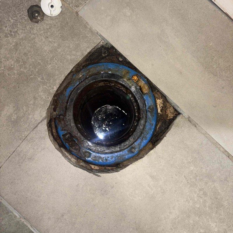 Responded to main drain backup in basement area. Customer had already removed toilet to access drain line. Utilized power drain cleaning machine with extended cable to clear blockage in main sewer line leading to street. Successfully snaked drain line beyond reach of customer's equipment, removing obstruction located near street connection. Cleared floor drain and tested system to confirm proper flow and drainage restored throughout property.
