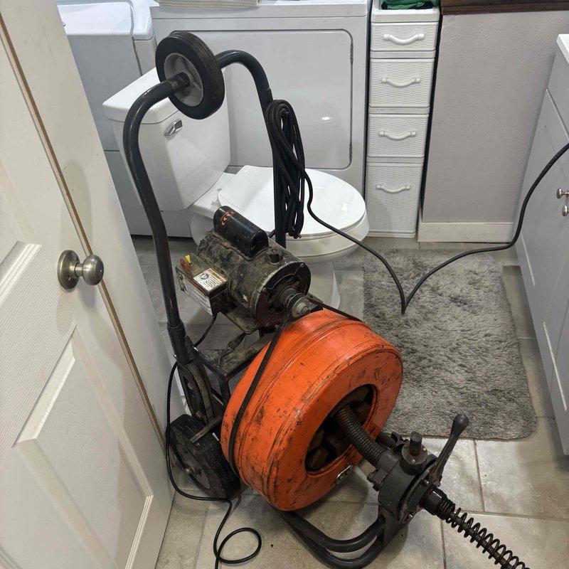 Responded to main drain backup in basement area. Customer had already removed toilet to access drain line. Utilized power drain cleaning machine with extended cable to clear blockage in main sewer line leading to street. Successfully snaked drain line beyond reach of customer's equipment, removing obstruction located near street connection. Cleared floor drain and tested system to confirm proper flow and drainage restored throughout property.