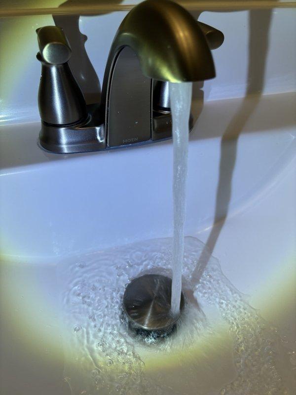 Completed plumbing maintenance visit addressing bathroom sink faucet operation and basement sump pump monitoring system inspection. Verified proper water flow from two-handle faucet fixture and confirmed basement watchdog alarm system was properly mounted and operational with secure power connections.