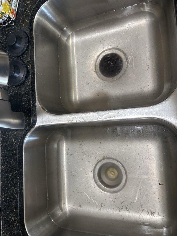 Responded to kitchen sink drainage issue in double-basin stainless steel sink. Upon arrival, assessed both basins and drain assembly for blockage obstruction. Cleared clog from drain line, restoring proper water flow and drainage function. Tested both basins to verify complete resolution, and sink is now draining properly with no standing water remaining.