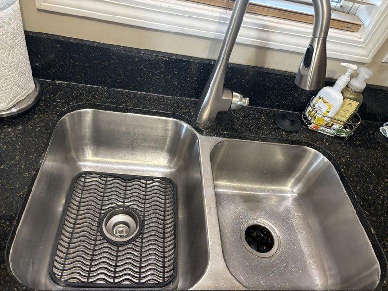 Responded to kitchen sink drainage issue in double-basin stainless steel sink. Upon arrival, assessed both basins and drain assembly for blockage obstruction. Cleared clog from drain line, restoring proper water flow and drainage function. Tested both basins to verify complete resolution, and sink is now draining properly with no standing water remaining.