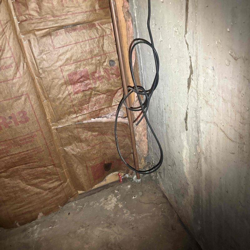 Responded to service call for no hot water condition affecting entire residence. Upon arrival, located water heater in basement area and performed comprehensive diagnostic assessment. Inspection revealed failed water heater requiring replacement. Documented existing plumbing infrastructure including copper supply lines, shut-off valve configuration, and electrical connections in unfinished basement space. Photographed installation area showing exposed stud walls with insulation, concrete flooring, and existing utility routing to provide accurate estimate for water heater replacement and associated connection work.