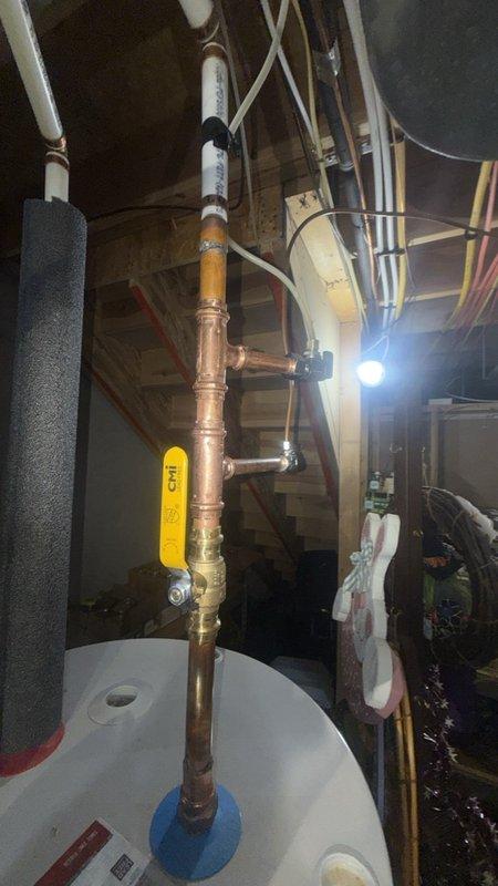 Responded to complete plumbing installation following HVAC technician's saddle ball valve work on A.O. Smith tanked water heater. Connected and secured copper piping assembly with proper fittings, applied insulation wrap to exposed sections, and verified all connections for proper water flow and leak prevention. System tested and confirmed operational with no active leaks detected at completion.