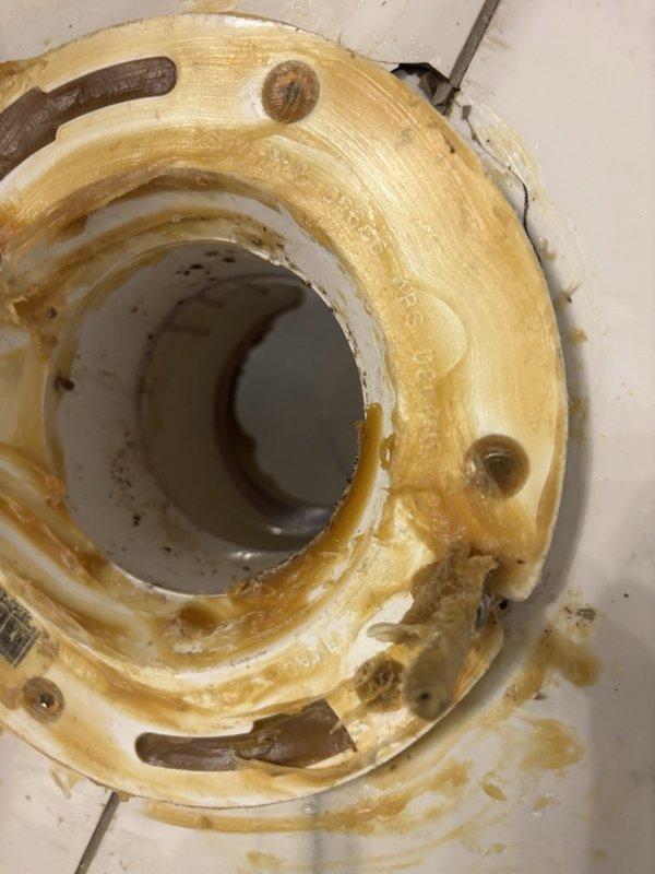 Responded to main floor bathroom with shower backup and water surfacing around toilet base following recent city sidewalk construction. Upon arrival, found toilet in severely deteriorated condition with extensive mineral deposits, rust staining, and corroded mounting bolts. City water department had previously cleared main line with no issues found. Removed and replaced failing toilet fixture with new two-piece unit, installed with proper wax ring seal and new supply line. Verified proper drainage and seal integrity. Testing confirmed no further water backup issues at toilet or shower drain. New fixture installed and operational.