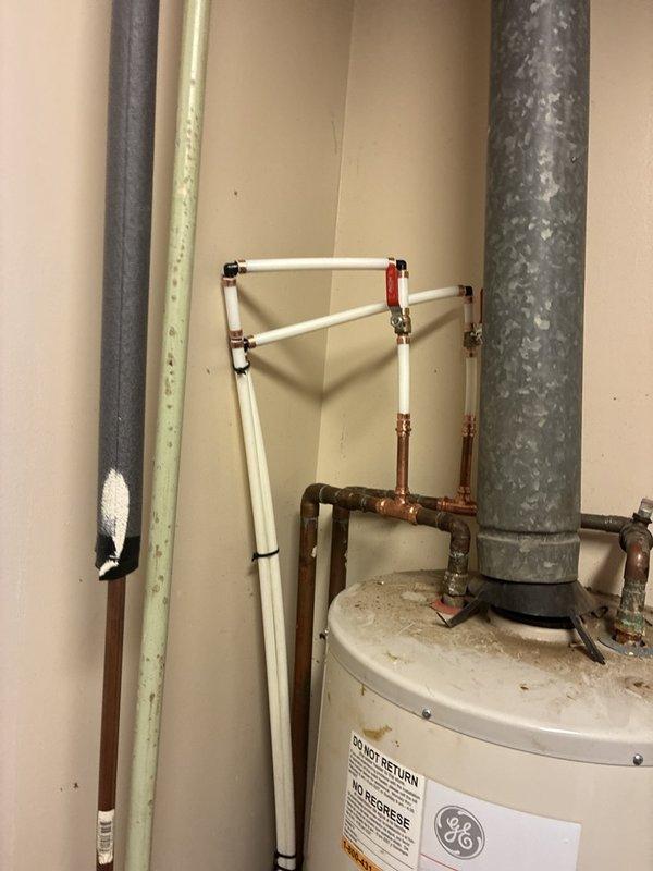 Installed a new 2" PVC drain line by tying into an existing 2" stack located in the cavity between the men's and women's restrooms, routing the drain line through the wall to a new washing machine location in the accessible restroom stall. Ran PEX water supply lines from the water heater room to the new laundry box location, installing shut-off valves at the water heater connections with red and blue valve handles. Removed necessary sheetrock sections to access stud cavities for pipe routing, installed the laundry box with venting extended into the attic space, and secured all piping with stud guards and mounting brackets to protect against future damage. Pressure tested all connections for leaks, verified proper drainage, and cleaned the work area of all construction debris upon completion.