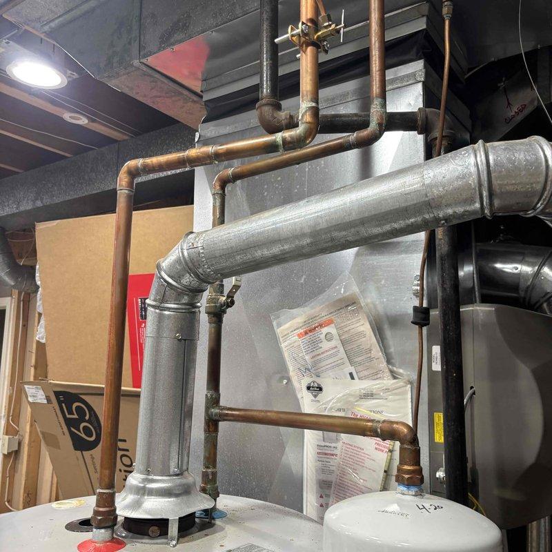 Completed comprehensive plumbing inspection of residential water heating system. Inspected A.O. Smith 40-gallon natural gas water heater (Model GCR-40 400, manufactured March 2020) including verification of proper venting through galvanized flue pipe with elbow configuration, assessment of copper supply line connections showing age-appropriate patina, and examination of gas manifold pressures per manufacturer specifications. All components photographed and documented for record, with system found operational at time of inspection.