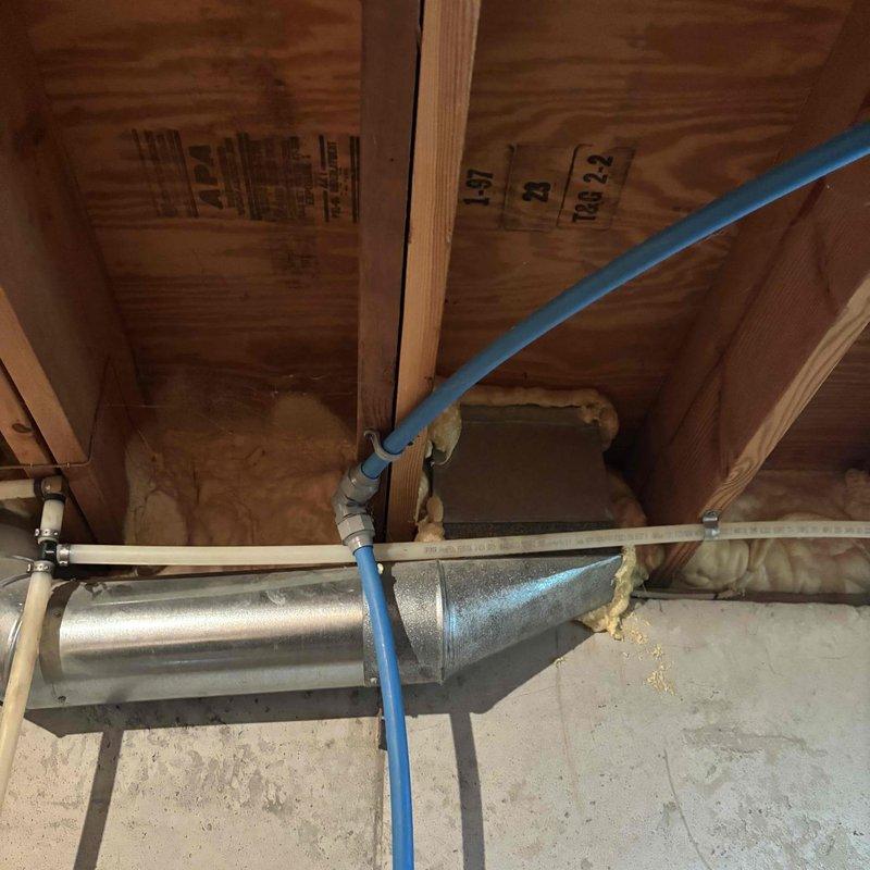 Repaired approximately 3 feet of damaged water line in the attic space. Removed the existing compromised section and installed new copper piping with brass fittings, connecting to the blue PEX supply line. Installed shut-off valves with red handles for future service access and tested the system for proper flow and leak-free operation.