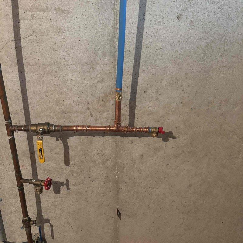 Repaired approximately 3 feet of damaged water line in the attic space. Removed the existing compromised section and installed new copper piping with brass fittings, connecting to the blue PEX supply line. Installed shut-off valves with red handles for future service access and tested the system for proper flow and leak-free operation.