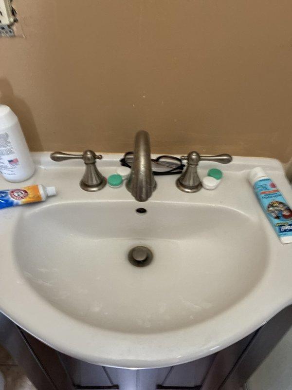 Responded to clogged bathroom sink on main level. Upon inspection, identified blockage in drain line beneath vanity. Accessed plumbing from basement level and cleared obstruction from cast iron drain pipe using appropriate drain clearing equipment. Verified proper drainage flow at fixture and confirmed no leaks at connections. Sink now draining properly with full water flow restored.