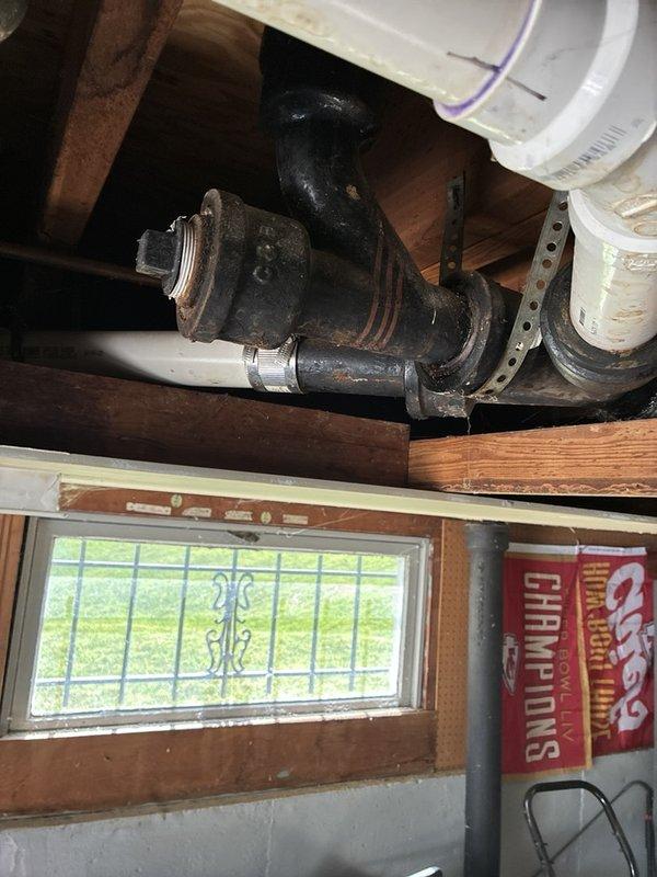 Responded to clogged bathroom sink on main level. Upon inspection, identified blockage in drain line beneath vanity. Accessed plumbing from basement level and cleared obstruction from cast iron drain pipe using appropriate drain clearing equipment. Verified proper drainage flow at fixture and confirmed no leaks at connections. Sink now draining properly with full water flow restored.