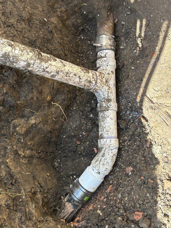 Completed sewer line replacement using pipe bursting method to install new piping under driveway with minimal landscape disturbance. Excavated trenches on both sides of driveway at previous repair location and extended excavation near main line to remove deteriorated clay tile piping. Utilized hydraulic expansion equipment with cable and winch system to pull new same-size pipe through existing line, bursting original pipe during installation. Heat-welded replacement pipe sections above ground to ensure strong, durable connections throughout the run. Successfully removed compromised clay tile sections and established new continuous sewer line from property connection to main, restoring proper wastewater conveyance.