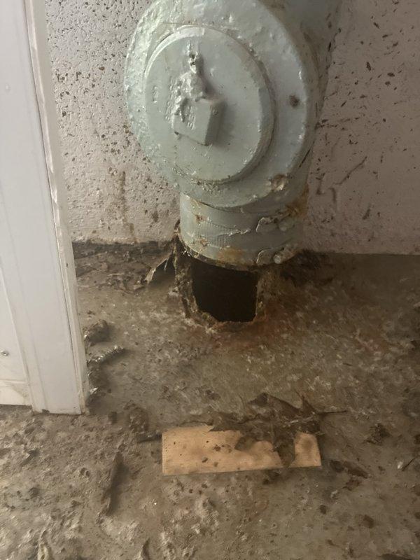 Performed camera inspection of main drain line in basement to assess reported breaks and determine repair or replacement requirements. Documentation revealed significant deterioration at pipe penetration point through floor with visible structural damage to concrete and exposed void beneath foundation. Sump pump pit area inspected showing standing water and evidence of chronic moisture issues with surrounding floor surfaces displaying extensive water damage, soil accumulation, and debris. Photographed vertical drain stack showing advanced deterioration with compromised pipe integrity and floor drain connections. Assessment indicates main line damage requiring excavation and replacement, with additional evaluation needed for potential washing machine drain line installation to address drainage deficiencies contributing to observed water infiltration and basement flooding conditions.