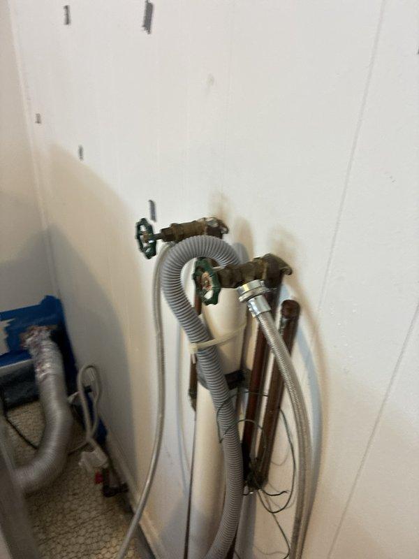 Replaced hot and cold shut-off valves for kitchen sink faucet installation. Removed old brass valves showing signs of corrosion and water staining, installed new quarter-turn shut-off valves, and reconnected braided stainless steel supply lines to ensure proper water flow and temperature control to the chrome kitchen faucet with dual handles.