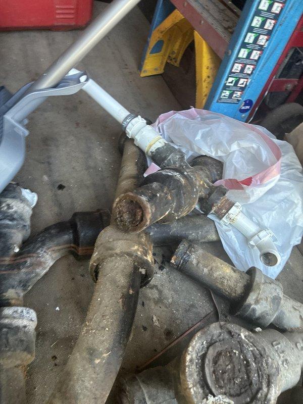 Completed full repipe of existing plumbing system, removing severely corroded metal piping and fittings that had deteriorated beyond serviceable condition. Installed new PVC drainage system including P-trap configuration under sink area, ensuring proper venting and code-compliant connections with secure fittings and clamps.