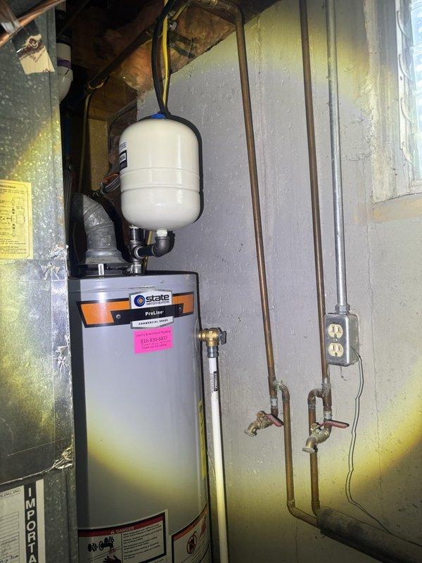 Responded to service call for tankless water heater pricing consultation. Inspected existing State brand tank-style water heater located in basement, currently operational and under 10 years old. Unit features standard expansion tank installation with copper supply lines and appropriate shut-off valves. Evaluated existing plumbing configuration, venting requirements, and electrical connections to determine feasibility of tankless conversion. Documented current installation with photographs showing water heater, expansion tank, piping layout, and utility space conditions. Provided customer with comprehensive pricing estimate for tankless water heater installation, including discussion of capacity requirements, necessary modifications to gas lines or electrical service, venting changes, and potential structural considerations based on current basement setup.