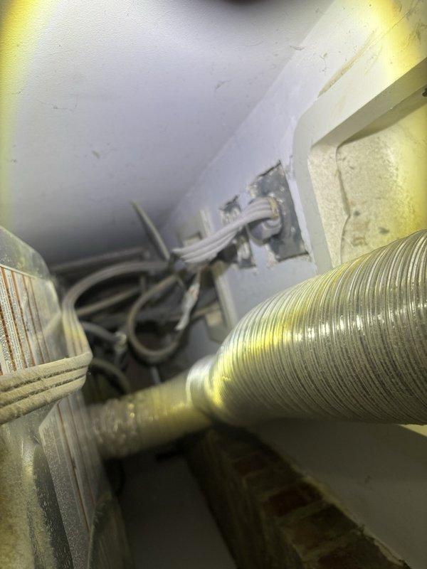 Responded to reported water leak causing a three-foot crack and continuous dripping in kitchen ceiling. Investigated source by accessing attic space above affected area and inspecting HVAC system, ductwork, and surrounding plumbing lines. Located leak origin in mechanical space and documented conditions with photographic evidence showing HVAC equipment, flexible ductwork, and evaporator coils, as well as adjacent laundry area with stacked washer/dryer unit to assess potential water source connections. Identified cause of ceiling damage and provided repair recommendations to resolve active leak and prevent further structural deterioration.