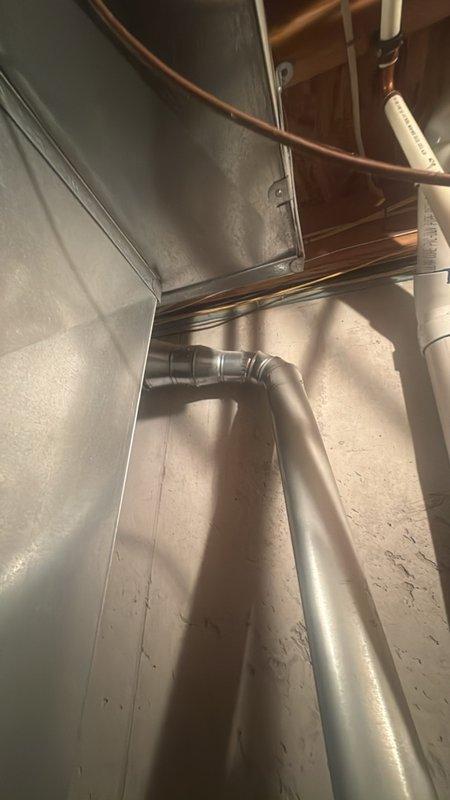 Responded to service call for leaking water heater in basement. Upon arrival, inspected residential water heater unit and surrounding plumbing connections, including copper supply lines and PVC drainage system. Identified source of leak, performed necessary repairs to stop water discharge, and verified proper operation of unit. Documented existing conditions with photographs showing water heater installation, associated ductwork, and plumbing configuration for service records.