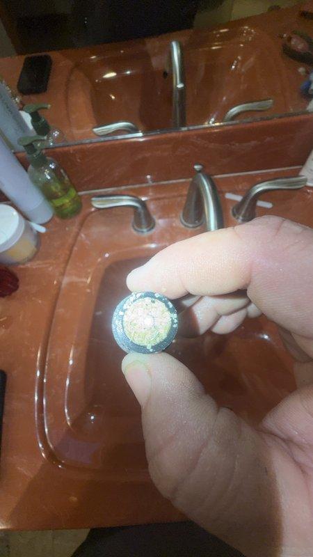 Responded to customer complaint of low water pressure in shower. Upon inspection, discovered significant mineral buildup and sediment accumulation in faucet aerator, which was restricting water flow throughout the fixture. Removed and cleaned aerator, revealing heavy calcium and lime deposits typical of hard water conditions. Inspected water heater and main plumbing connections to rule out system-wide pressure issues. Advised customer that shower plumbing is embedded in concrete slab, which would require extensive demolition and repair work if main supply lines are compromised. Recommended monitoring pressure at other fixtures and considering whole-house water softener system to prevent future mineral buildup. Customer expressed need to discuss major repair options with spouse before proceeding with any concrete work.