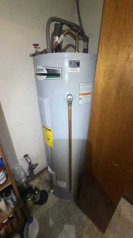 Responded to customer complaint of low water pressure in shower. Upon inspection, discovered significant mineral buildup and sediment accumulation in faucet aerator, which was restricting water flow throughout the fixture. Removed and cleaned aerator, revealing heavy calcium and lime deposits typical of hard water conditions. Inspected water heater and main plumbing connections to rule out system-wide pressure issues. Advised customer that shower plumbing is embedded in concrete slab, which would require extensive demolition and repair work if main supply lines are compromised. Recommended monitoring pressure at other fixtures and considering whole-house water softener system to prevent future mineral buildup. Customer expressed need to discuss major repair options with spouse before proceeding with any concrete work.