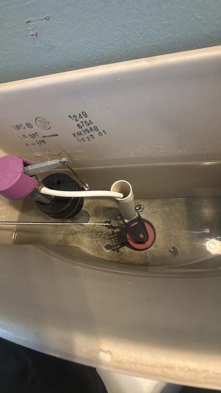 Responded to callback for recurring slow leak near toilet in residential bathroom. Upon arrival, inspected pedestal sink, toilet base, and surrounding plumbing connections for signs of active water intrusion. Examined water heater tank interior through access opening, documenting sediment buildup and mineral deposits at base of tank. Identified pink valve assembly and white PVC connections showing signs of previous service work. Photographed bathroom fixtures and water heater interior conditions for documentation purposes. Leak source traced to previous repair area requiring additional attention.