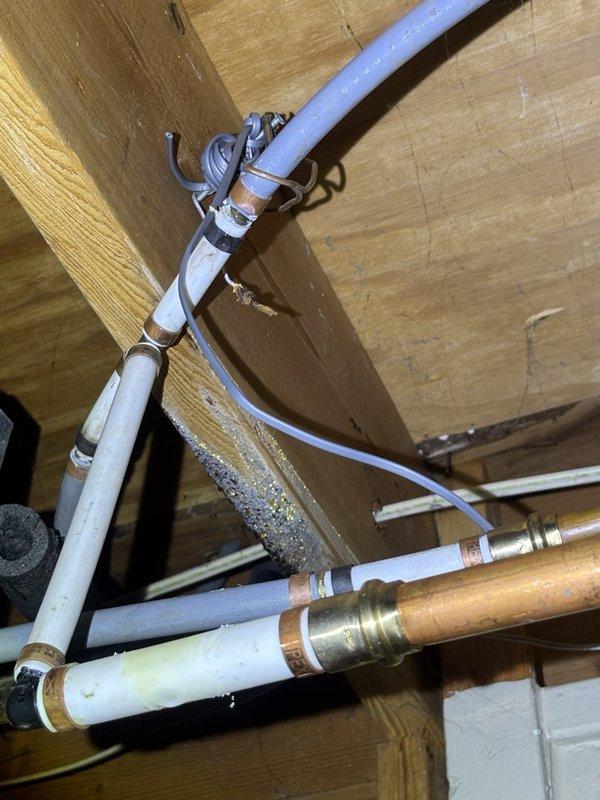 Responded to service call for reported water heater leak and rust concerns on gas-fired unit in basement. Upon arrival, conducted thorough inspection of water heater and surrounding plumbing infrastructure. Examination revealed no active leaking from the water heater tank itself. Observed frost accumulation on overhead wooden beams near plumbing runs, indicating potential condensation issues in the utility space. Inspected all visible copper piping, PEX connections, and brass fittings for signs of moisture or corrosion. Verified gas water heater connections and venting system integrity. Documented existing conditions with photographs showing plumbing infrastructure, HVAC ductwork, and utility space configuration. Advised customer that observed frost buildup may be contributing to moisture concerns rather than water heater failure. Unit operational at time of inspection with no immediate safety concerns identified.