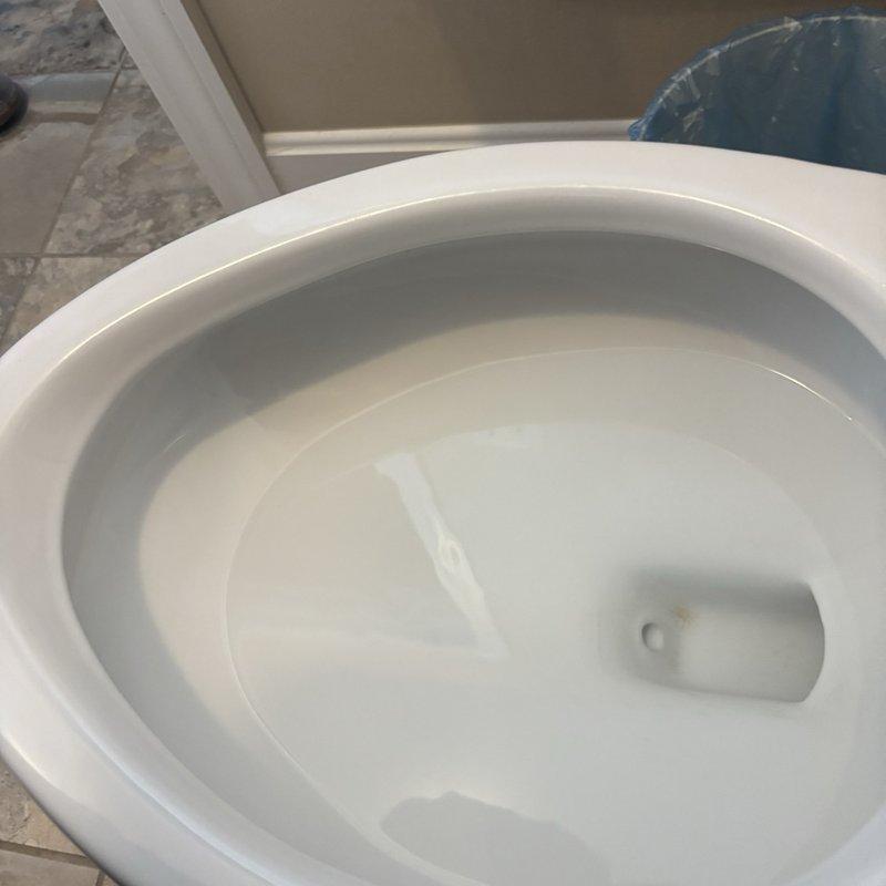 Inspected the toilet for slow drainage and found the bowl holding clear water with no visible obstruction at the drain opening. Checked the braided stainless steel supply line and chrome angle stop valve and found them intact with no leaks. Performed drain clearing and test-flushed the unit to confirm proper flow and operation.
