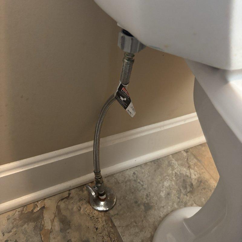 Inspected the toilet for slow drainage and found the bowl holding clear water with no visible obstruction at the drain opening. Checked the braided stainless steel supply line and chrome angle stop valve and found them intact with no leaks. Performed drain clearing and test-flushed the unit to confirm proper flow and operation.